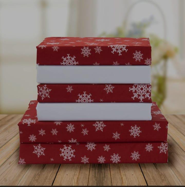 Red bed sheet set with white snowflake print, folded