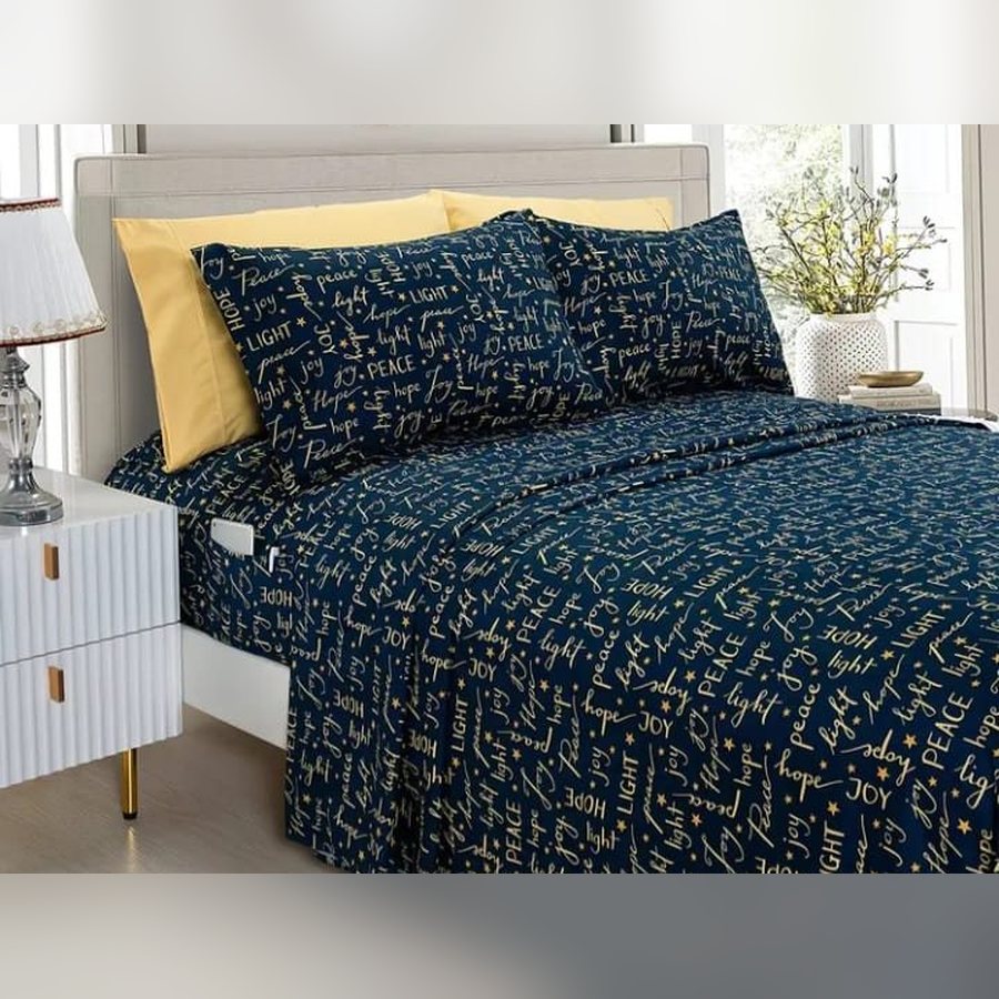 Navy Joy and Peace sheet set on a bed