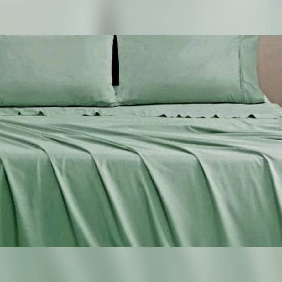 Sage green Quatan sheet set on a queen bed